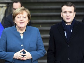 German Chancellor Angela Merkel, left, and French President Emmanuel Macron, right, arrive at the townhall in Aachen, Germany, Tuesday, Jan. 22, 2019. German Chancellor Angela Merkel and French President Emmanuel Macron are meeting in Aachen to sign a friendship treaty that recalls a historic pact the former enemies agreed in 1963.