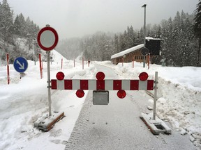 Due to the danger of an avalanche a mountain pass road is closed in Obermaiselstein, Germany, Sunday, Jan. 13, 2019.