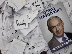 FILE - In this Wednesday, March 18, 2015 file photo, an election campaign poster with the image of Israeli Prime Minister Benjamin Netanyahu lies among ballot papers at his party's election headquarters, in Tel Aviv. Israel's Shin Bet security service says it's able to thwart any foreign intervention in the country's upcoming elections in April 2019, after its director warned of such efforts. (