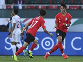 South Korea's Hwang Hee-Chan, right, celebrates after he scored first goal during the AFC Asian Cup round of 16 soccer match between South Korea and Bahrain at the Rashid Stadium in Dubai, United Arab Emirates, Tuesday, Jan. 22, 2019.