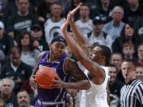 Northwestern's Dererk Pardon, left, maneuvers against Michigan State's Nick Ward during the first half of an NCAA college basketball game, Wednesday, Jan. 2, 2019, in East Lansing, Mich.