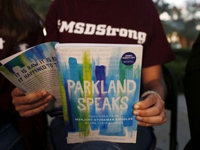In this Wednesday, Jan. 16, 2019, photo, Leni Steinhardt, 16, reads from a new book called "Parkland Speaks: Survivors from Marjory Stoneman Douglas Share Their Stories," during an interview with The Associated Press, in Parkland, Fla.