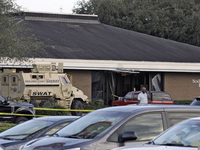 A Highlands County Sheriff's SWAT vehicle is stationed out in front of a SunTrust Bank branch, Wednesday, Jan. 23, 2019, in Sebring, Fla., where authorities say five people were shot and killed.