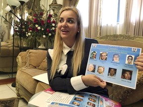 In this Oct. 15, 2018 photo, Darling Perez shows a copy of a Nicaraguan government wanted poster in which she is listed, during an interview in Miami. Perez, a pediatrician, worked at a public hospital in Nicaragua and was told not to take care of patients who were hurt during protests. She refused and began helping wounded students at private clinics. Perez, her husband and 12-month-old baby, all of whom arrived in the U.S. on tourist visas, are now seeking asylum in the U.S.