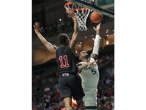 Miami guard Zach Johnson (5) goes up for a shot against North Carolina State guard Markell Johnson (11) during the first half of an NCAA college basketball game, Thursday, Jan. 3, 2019, in Coral Gables, Fla.