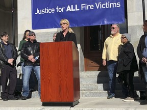 Consumer advocate Erin Brockovich, who famously took on Pacific Gas & Electric Co. in the 1990s, stands with wildfire victims and speaks outside the state Capitol Tuesday, Jan. 22, 2019, in Sacramento, Calif. Brockovich is urging California lawmakers not to let PG&E go bankrupt because it might mean less money for wildfire victims.