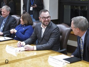 FILE - In this Jan. 8, 2019, file photo, Alaska Department of Administration Commissioner Jonathan Quick, second from right, speaks with Revenue Commissioner Bruce Tangeman, right, before the start of a cabinet meeting at the state Capitol in Juneau, Alaska. Quick, a member of Alaska Gov. Mike Dunleavy's cabinet, has been accused of lying about his business background that he had an ownership interest in Anthem Coffee and Tea and Elements Frozen Yogurt. Meanwhile, Art Chance, in Quick's department faces scrutiny for racially charged and misogynistic social media comments.