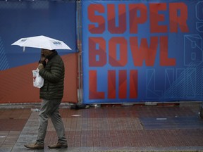 A person walks through Centennial Olympic Park on a rainy morning ahead of the NFL Super Bowl 53 football game, Tuesday, Jan. 29, 2019, in Atlanta. The New England Patriots face the Los Angeles Rams Sunday, Feb., 2, 2019.