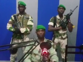 In this image from TV, a soldier who identified himself as Lt. Obiang Ondo Kelly, commander of the Republican Guard, reads a statement on state television broadcast from Libreville, saying the military has seized control of the government, Monday Jan. 7, 2019.  The statement said Soldiers from Gabon's Republican Guard have launched a coup "to restore democracy" in the West African country, while imposing a curfew in the capital, and the internet has been cut.  No violence has been reported and President Ali Bongo has been out of the country since October amid reports that he had a stroke.(Gabon State TV via AP)