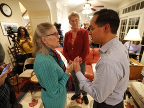 Former Housing and Urban Development Secretary Julian Castro talks with Julie Wittig, of Iowa City, Iowa, left, during a house party at the Ed and Jane Cranston home, Monday, Jan. 7, 2019, in North Liberty, Iowa.