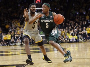Michigan State guard Cassius Winston (5) drives past Iowa guard Isaiah Moss (4) during the first half of an NCAA college basketball game Thursday, Jan. 24, 2019, in Iowa City, Iowa.