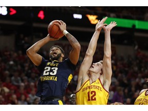 West Virginia forward Esa Ahmad, left, shoots over Iowa State forward Michael Jacobson during the first half of an NCAA college basketball game Wednesday, Jan. 30, 2019, in Ames, Iowa.