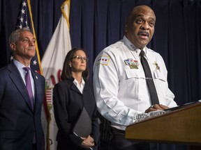 FILE - In this Aug. 29, 2018 file photo, Chicago Police Superintendent Eddie Johnson, accompanied by Illinois Attorney General Lisa Madigan, center, and Chicago Mayor Rahm Emanuel, speaks at a news conference in Chicago. Preliminary numbers show homicides in Chicago fell by about 100 over the last year compared to 2017 according to a police report on Tuesday, Jan. 1, 2019.