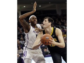 Iowa forward Ryan Kriener, right, looks to the basket as Northwestern center Dererk Pardon guards during the first half of an NCAA college basketball game Wednesday, Jan. 9, 2019, in Evanston, Ill.