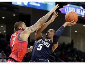 Villanova guard Phil Booth, right, shoots against DePaul guard Devin Gage during the first half of an NCAA college basketball game Wednesday, Jan. 30, 2019, in Chicago.