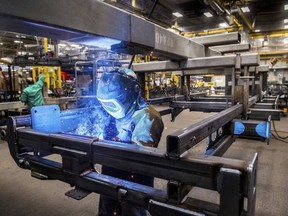 FILE- In this Dec. 5, 2018, file photo, Tyler Snowden of Case IH-Goodfield, welds a field cultivator main frame on the shop floor at the plant in Goodfield, Ill. On Friday, Jan. 18, 2019, the Federal Reserve reports on U.S. industrial production for December.