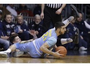 Marquette's Joseph Chartouny (21) makes a pass against Butler's Sean McDermott during the first half of an NCAA college basketball game, Wednesday, Jan. 30, 2019, in Indianapolis.