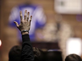 A Purdue football player raises his hand while singing a song during a funeral for Tyler Trent at College Park Church, Tuesday, Jan. 8, 2019, in Indianapolis. Trent, an avid Purdue fan, died on New Year's Day, following a bout with bone cancer.
