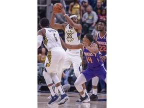 Indiana Pacers center Myles Turner (33) keeps the ball from Phoenix Suns' De'Anthony Melton (14) during the first half of an NBA basketball game Tuesday, Jan. 15, 2019, in Indianapolis.