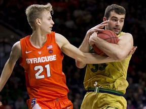 Notre Dame's John Mooney (33) grabs a rebound next to Syracuse's Marek Dolezaj (21) during the first half of an NCAA college basketball game Saturday, Jan. 5, 2019, in South Bend, Ind.