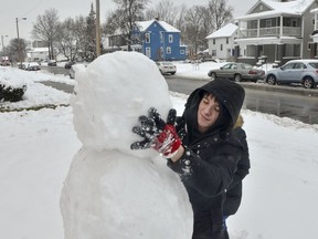 Blake Wise applies the head of the snowman that he and Brianna Atwood built along South 7th Street in Terre Haute, Ind., on Saturday, Jan. 12, 2019. A massive winter snowstorm making its way across the Midwest and into the Mid-Atlantic region blanketed most of Missouri and several other states.