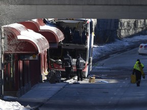 Transport Canada officials look at the scene where a double-decker city bus struck a transit shelter at the start of the afternoon rush hour on Friday, at Westboro Station in Ottawa, on Saturday, Jan. 12, 2019.