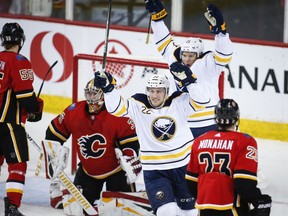 Buffalo Sabres' Johan Larsson, centre, of Sweden, and Kyle Okposo, right, celebrate their team's goal as Calgary Flames goalie David Rittich, of the Czech Republic, looks away during third period NHL hockey action in Calgary, Wednesday, Jan. 16, 2019.