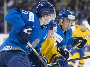Kazakhstan's Ruslan Dyomin (26) and Valeri Orekhov (9) sandwich Sweden's Rickard Hugg (26) during third period IIHF world junior hockey action in Victoria on Monday, Dec. 31, 2018.