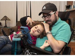 Aymen Derbali enjoys some quality time with his daughter Maryem in their home, in Quebec City, Thursday, Jan. 24, 2019. Two years ago, on Jan. 29, 2017, a gunman's rampage at the Quebec Mosque left Derbali paralyzed.
