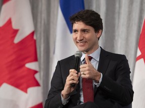 Prime Minister Justin Trudeau gives the thumbs up after he was given a microphone that worked, at a chamber of commerce luncheon, Friday, January 25, 2019 in Quebec City.