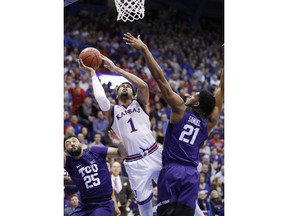 Kansas forward Dedric Lawson (1) rebounds a ball as Texas Christian guard Alex Robinson (25) center Kevin Samuel (21) defend during the first half of an NCAA college basketball game, Wednesday, Jan. 9, 2019, in Lawrence, Kan.