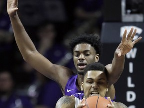 Kansas State forward Levi Stockard III (34) rebounds against TCU center Russell Barlow, back, during the first half of an NCAA college basketball game in Manhattan, Kan., Saturday, Jan. 19, 2019.