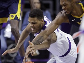 Kansas State forward Levi Stockard III (34) dives for the ball against West Virginia forward Derek Culver, right, during the first half of an NCAA college basketball game in Manhattan, Kan., Wednesday, Jan. 9, 2019.