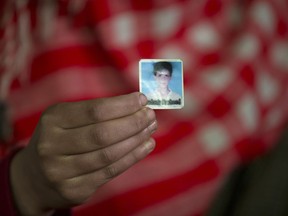 In this Dec. 26, 2018 photo, Maymoona Rashid holds the only photograph she has of her brother Mudassir Rashid Parray in Hajin village, north of Srinagar, Indian controlled Kashmir. Mudassir, who was then 14-years-old, and another teenager walked away from a local soccer pitch in the Kashmiri town of Hajin on a hot day in August, only to return home months later in body bags. Dying with his teammate in an 18-hour firefight in December, Mudassir became the youngest militant slain fighting Indian troops in a three-decade insurgency in Kashmir.