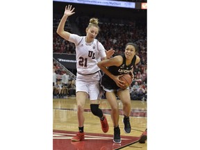 Connecticut forward Kyla Irwin (25) attempts to drive past Louisville forward Kylee Shook (21) during the first half of an NCAA college basketball game in Louisville, Ky., Thursday, Jan. 31, 2019.