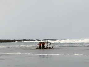 This Tuesday, Jan. 8, 2019 photo provided by the Oregon State Police shows authorities in Newport, Ore., examine the wreckage of the Mary B. II, a commercial crabbing that capsized while crossing Yaquina Bay Bar off the coast of Newport, Ore. Three crew members died in the accident.( Oregon State Police via AP)