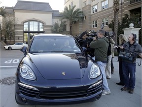 FILE - In this March 3, 2015 file photo, resident Jin-Jou Lu sits in his vehicle while talking to reporters outside after federal agents raided an upscale apartment complex where authorities say a birth tourism business charged pregnant women $50,000 for lodging, food and transportation, in Irvine, Calif. Authorities announced they have charged 20 people in an unprecedented crackdown on businesses that helped hundreds of Chinese women travel to the United States to give birth to American citizen children. The U.S. Attorney's office in Los Angeles says three people were arrested Thursday, Jan. 31, 2019 on charges including conspiracy, visa fraud and money laundering. More than a dozen others have also been charged in cases stemming from three so-called birth tourism businesses.