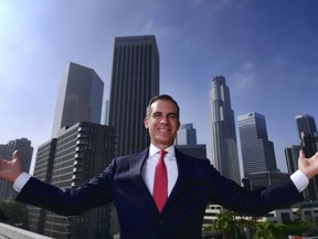 FILE - In this Aug. 23, 2018, file photo, Los Angeles Mayor Eric Garcetti poses for a photo in front of a sprawling downtown Los Angeles landscape. The Democratic mayor, who has said he will soon decide whether to enter the 2020 White House contest, would anchor his candidacy to the idea that local government is where things get done in America, in contrast to the turmoil and vast political divide in President Donald Trump's Washington.