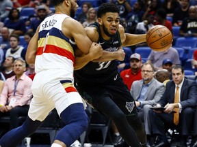 Minnesota Timberwolves center Karl-Anthony Towns (32) is fouled by New Orleans Pelicans center Jahlil Okafor (8) as he drives to the basket during the first half of an NBA basketball game, Monday, Dec. 31, 2018, in New Orleans.