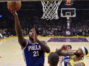 Philadelphia 76ers center Joel Embiid, left, shoots as Los Angeles Lakers forward Brandon Ingram, right, defends during the first half of an NBA basketball game Tuesday, Jan. 29, 2019, in Los Angeles.