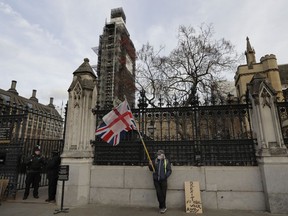 A lone demonstrator stands by an entrance to Britain's parliament in London, Friday, Jan. 18, 2019. Talks to end Britain's Brexit stalemate appeared deadlocked Friday, with neither Prime Minister Theresa May nor the main opposition leader shifting from their entrenched positions.