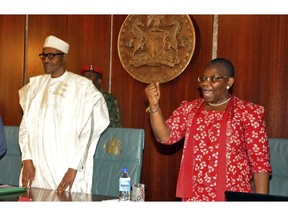 FILE - In this Wednesday, July 8, 2015 file photo, Nigerian President Muhammadu Buhari, left, stands next to Oby Ezekwesili, a coordinator of the 'Bring Back Our Girls' campaign, at the presidential residence in Abuja, Nigeria. The woman who led the global campaign to free Nigerian schoolgirls kidnapped by Boko Haram extremists is dropping out of the race for Nigeria's presidency, it was announced Thursday, Jan. 24, 2019. Oby Ezekwesili is the most prominent woman to seek the presidency in Nigeria, where politics, as in many African nations, have long been dominated by men.