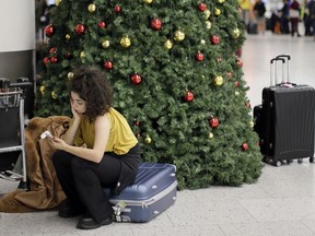 FILE - In this Thursday, Dec. 20, 2018 file photo, a woman waits in the departures area at Gatwick airport, near London, as the airport remains closed after drones were spotted over the airfield last night and this morning. London's Heathrow Airport suspended flight departures as a precaution Tuesday, Jan. 8, 2019 after a reported drone sighting that came just three weeks after a rash of drone sightings shut London's Gatwick Airport.