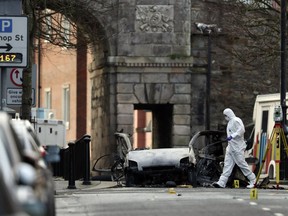 Forensic investigators at the scene of a car bomb blast on Bishop Street in Londonderry, Northern Ireland, Sunday, Jan. 20, 2019. Northern Ireland police and politicians have condemned a "reckless" car bombing outside a courthouse in the city of Londonderry. The device was placed inside a hijacked delivery vehicle and exploded Saturday night as police, who had received a warning, were evacuating the area. There were no reports of injuries.