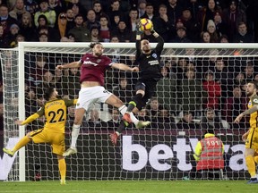 West Ham United's Andy Carroll (9) challenges Brighton & Hove Albion goalkeeper David Button for high ball during a Premier League soccer match at the London Stadium, Wednesday, Jan. 2, 2019, in London.