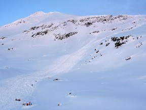 Rescue crew work at the scene of a 300-meter (990-foot) wide avalanche that hit the Tamok valley, near the northern city of Tromsoe, Norway, Thursday Jan. 17, 2019. Norwegian police say the body of one of the four skiers who were taken by an avalanche in northern Norway earlier this year, has been recovered. A police spokesman said Wednesday they would continue search efforts weather permitting, citing poor visibility.