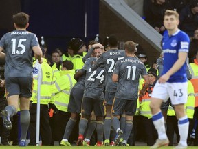 Leicester City's Jamie Vardy looks out as he is mobbed by team-mates after scoring his sides first goal of the game against Everton, during their English Premier League soccer match at Goodison Park in Liverpool, England, Tuesday Jan. 1, 2019.