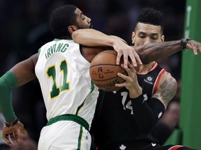 Boston Celtics guard Kyrie Irving (11) and Toronto Raptors guard Danny Green, right, tangle as they compete for the ball during the first quarter of an NBA basketball game in Boston, Wednesday, Jan. 16, 2019.