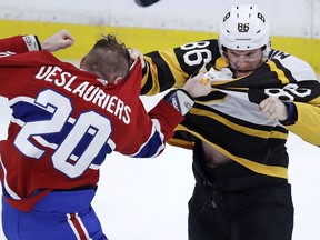 Boston Bruins defenseman Kevan Miller, right, fights Montreal Canadiens left wing Nicolas Deslauriers (20) during the first period of an NHL hockey game in Boston, Monday, Jan. 14, 2019.