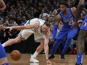 Boston Celtics forward Gordon Hayward (20) loses control of the ball next to Dallas Mavericks guard Wesley Matthews (23) during the first quarter of an NBA basketball game Friday, Jan. 4, 2019, in Boston.